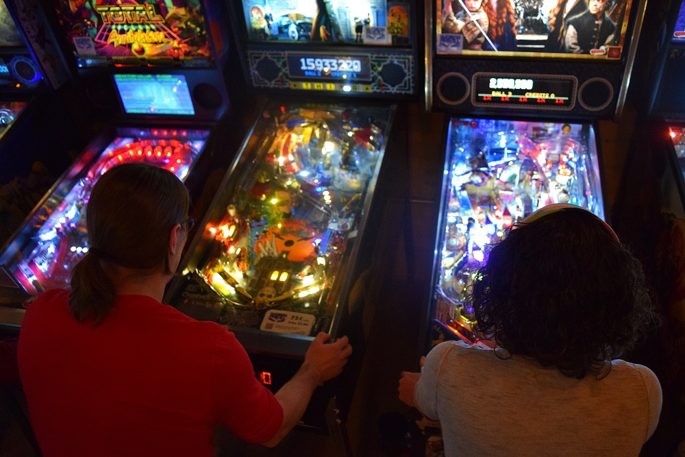 Hilton and Heidi Jones play pinball at Madison’s I/O Arcade Bar. (Jenny Peek/WPR)
