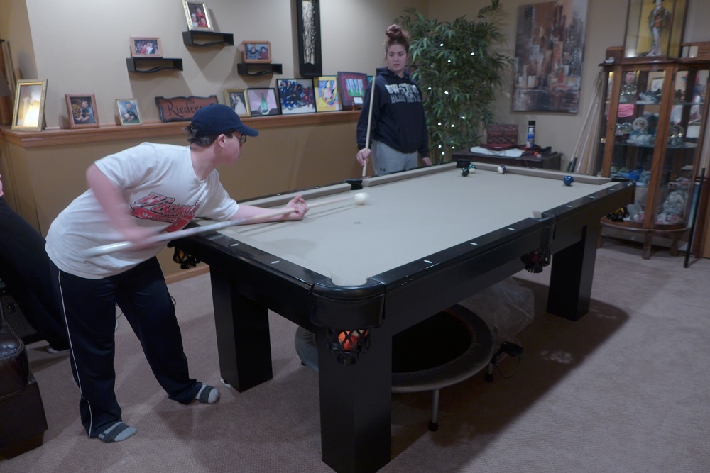 Siblings Thomas Riederer and Cierra Riederer play pool in the basement of their Cottage Grove home. (Maureen McCollum/WPR)