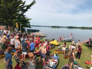 Participants with their kayaks and canoes ready themselves at the edge of the Wisconsin River flowage before the launch of PaddleQuest 2019. (Rob Mentzer/WPR)