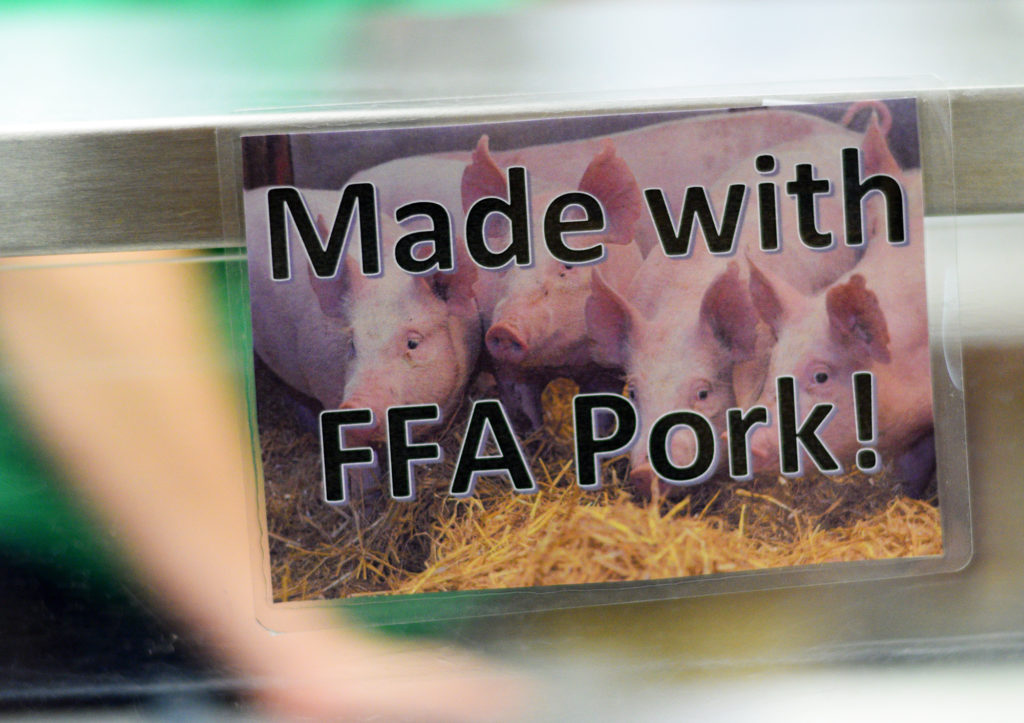 A sign notifies people who pass through the lunch line at Holmen High School that the marinara sauce was made with pork from pigs raised by FFA students. (Liz Dohms/WPR)